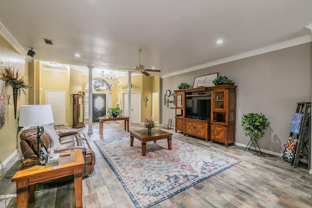 living area featuring visible vents, light wood-style floors, ornamental molding, and a ceiling fan