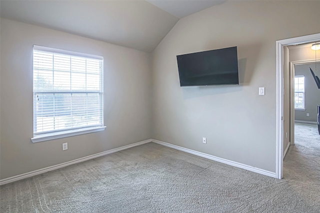 unfurnished room featuring carpet floors and vaulted ceiling