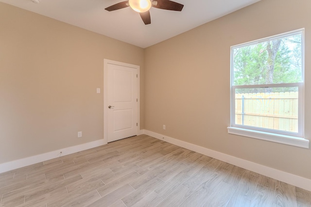 spare room featuring ceiling fan, plenty of natural light, and light wood-type flooring