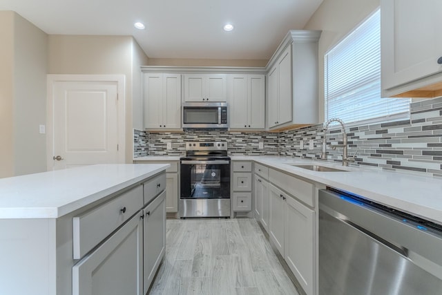 kitchen featuring tasteful backsplash, stainless steel appliances, a center island, and sink