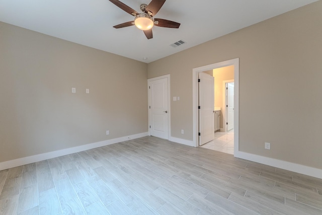 unfurnished bedroom with connected bathroom, ceiling fan, and light hardwood / wood-style flooring