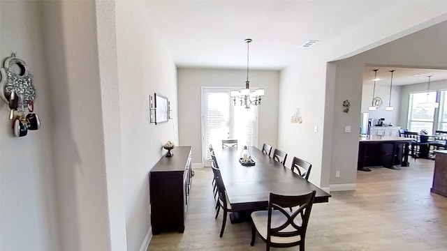 dining space featuring a chandelier and light hardwood / wood-style floors