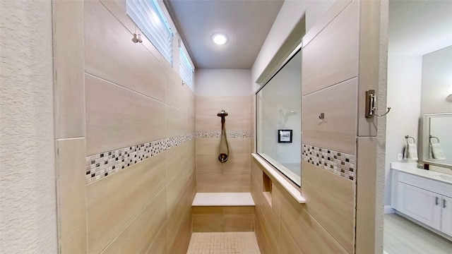 bathroom featuring tiled shower, vanity, and mail boxes