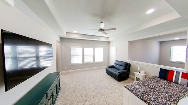 bedroom featuring ceiling fan, carpet flooring, and a raised ceiling