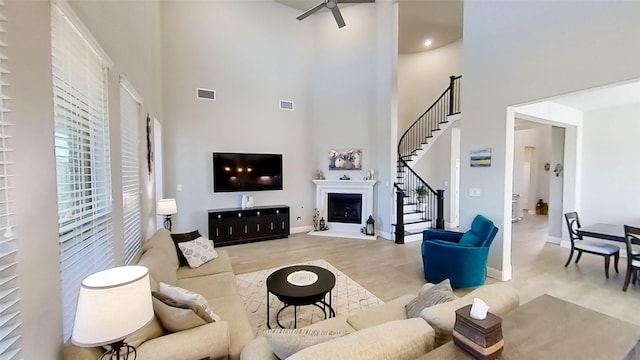 living room with a towering ceiling and light wood-type flooring