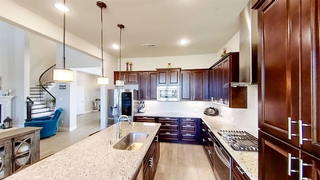 kitchen featuring sink, light stone counters, tasteful backsplash, hanging light fixtures, and stainless steel appliances