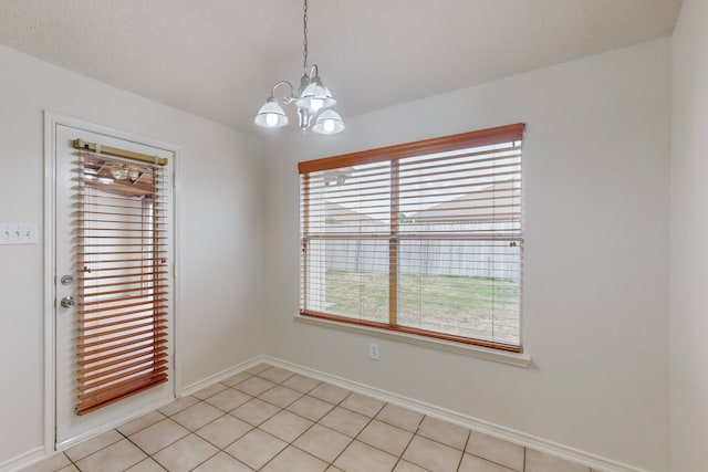 unfurnished room with an inviting chandelier, light tile patterned flooring, and a textured ceiling