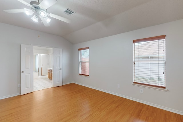 unfurnished room featuring vaulted ceiling, ceiling fan, and light wood-type flooring