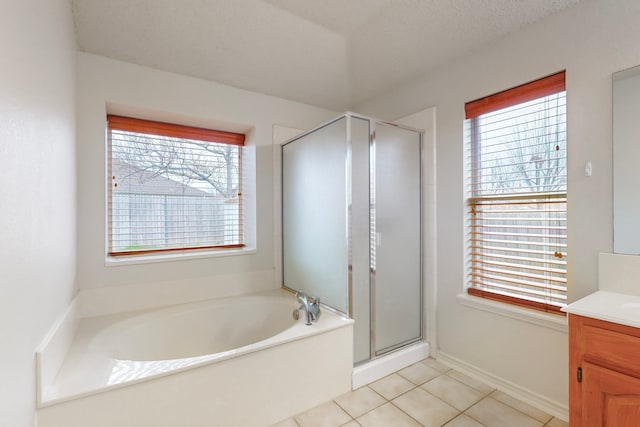 bathroom featuring vanity, a textured ceiling, tile patterned floors, and separate shower and tub