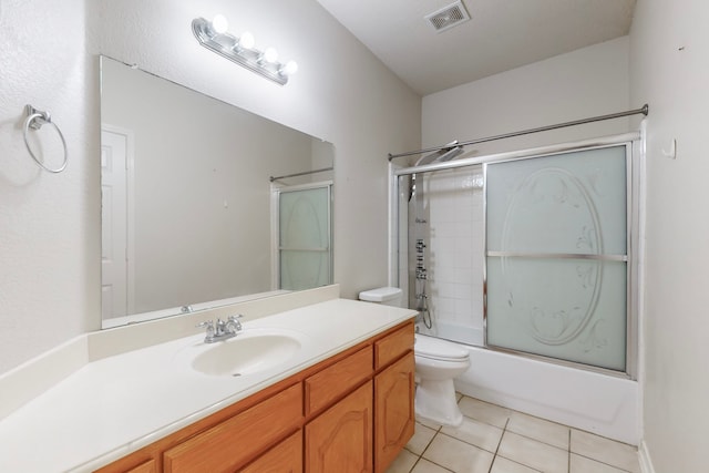 full bathroom with vanity, combined bath / shower with glass door, tile patterned floors, and toilet