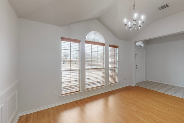 3821 Red Oak St, Sachse, TX 75048 - spare room featuring a chandelier, vaulted ceiling, light wood-style floors, and baseboards