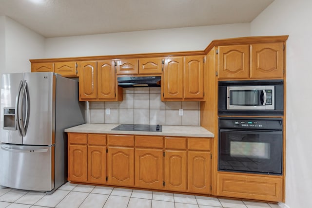 kitchen featuring tasteful backsplash, light tile patterned floors, and black appliances