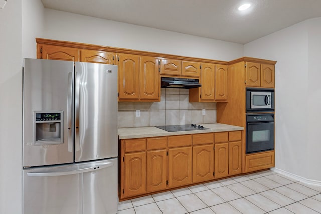 kitchen with backsplash, light tile patterned flooring, and black appliances