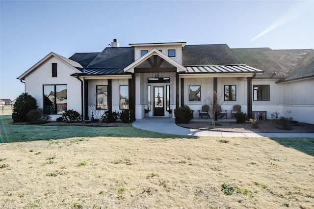 modern farmhouse style home with a front lawn