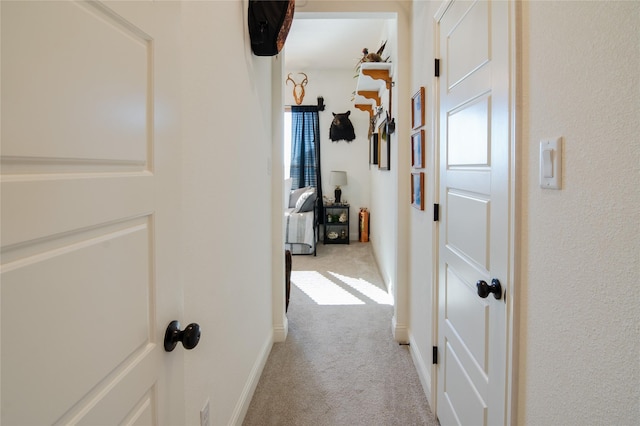 hallway featuring light colored carpet