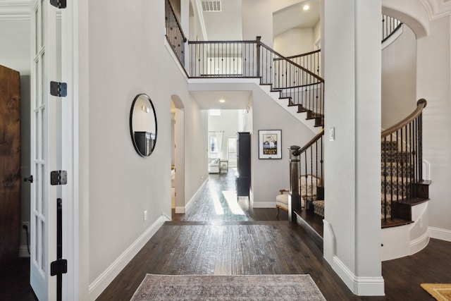 entryway with a towering ceiling, baseboards, and hardwood / wood-style flooring