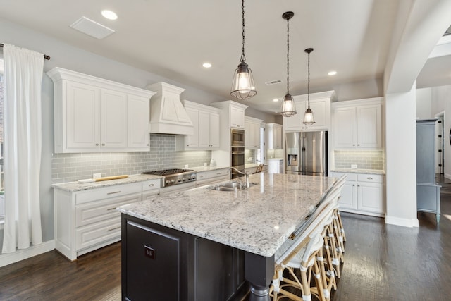 kitchen with stainless steel appliances, premium range hood, a sink, a large island, and dark wood-style floors