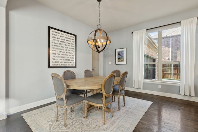 dining area with a chandelier, baseboards, and wood finished floors