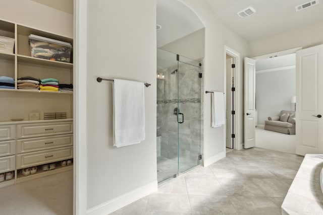 full bathroom featuring a shower stall, a spacious closet, visible vents, and baseboards