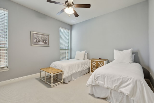 carpeted bedroom with visible vents, multiple windows, baseboards, and a ceiling fan