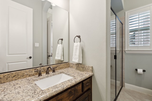 full bath with baseboards, a shower stall, vanity, and tile patterned floors