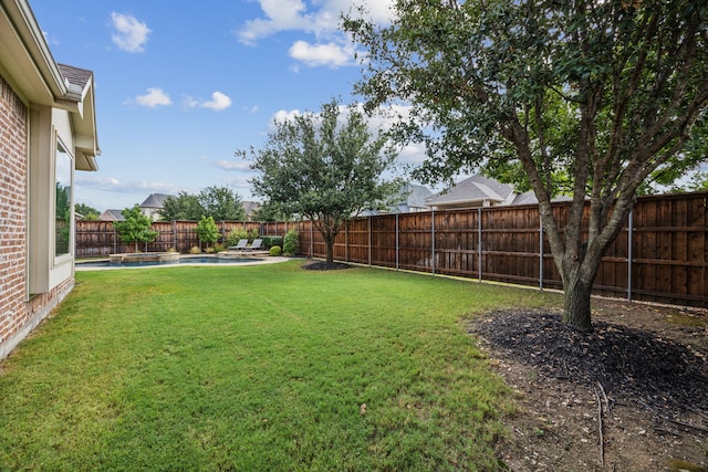 view of yard featuring a fenced backyard and a pool with connected hot tub