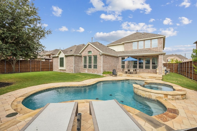 back of house featuring a fenced backyard, a yard, a patio area, a pool with connected hot tub, and brick siding