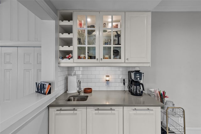 bar with white cabinetry, sink, and decorative backsplash