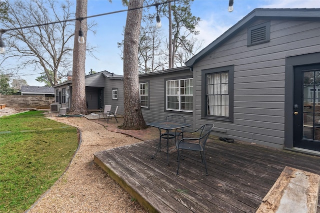 wooden terrace featuring central AC unit and a yard