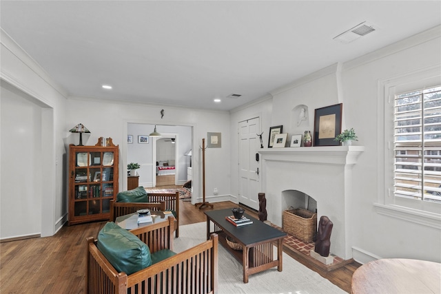 living room with wood-type flooring and ornamental molding