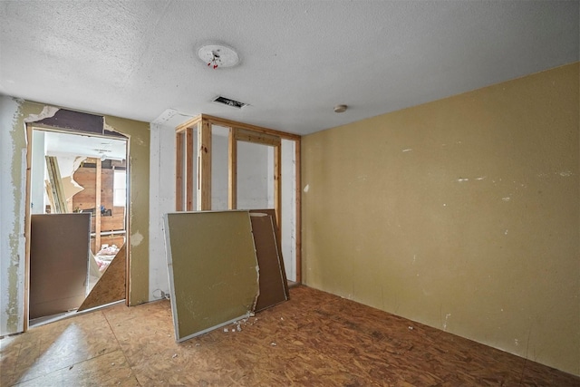 unfurnished room with a textured ceiling