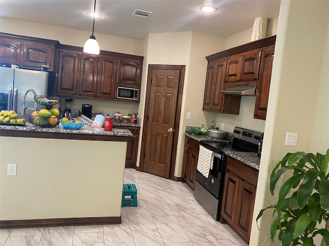 kitchen with hanging light fixtures, appliances with stainless steel finishes, dark brown cabinetry, and dark stone counters