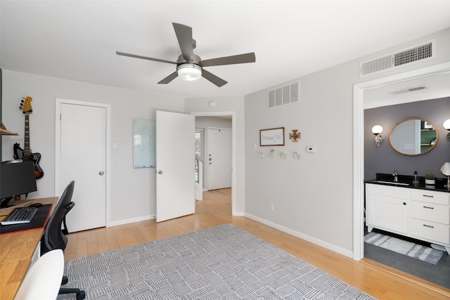 office area featuring ceiling fan, sink, and light hardwood / wood-style flooring