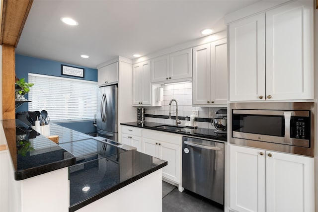 kitchen featuring appliances with stainless steel finishes, sink, white cabinets, and decorative backsplash