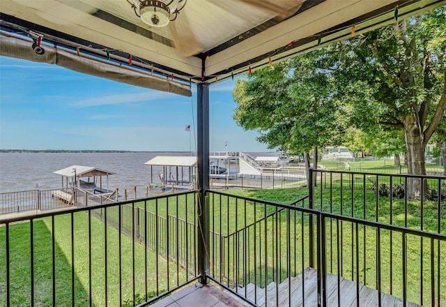 balcony featuring a boat dock, a water view, and boat lift