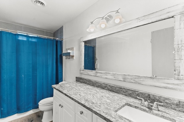 bathroom featuring vanity, wood-type flooring, and toilet