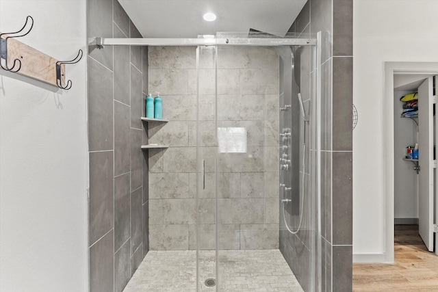 bathroom featuring hardwood / wood-style flooring and a shower with shower door