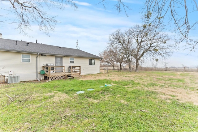 back of property with a deck, a lawn, and central air condition unit