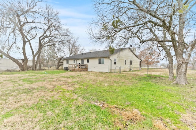 rear view of property featuring a yard and a deck