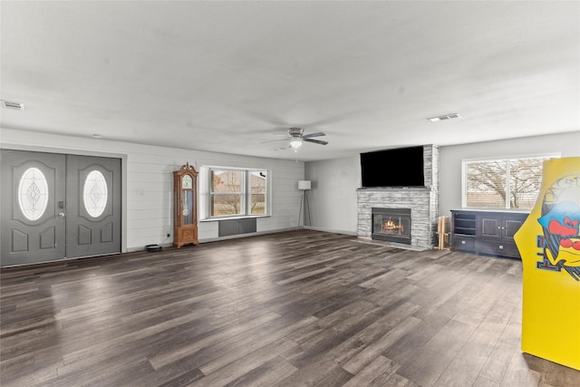 unfurnished living room with ceiling fan, a fireplace, and dark hardwood / wood-style floors