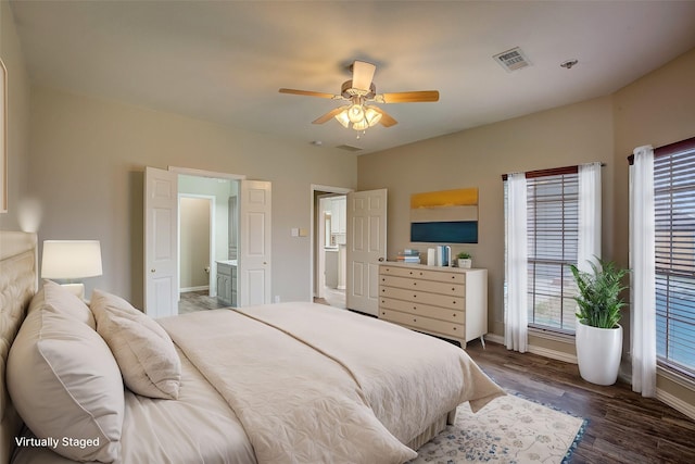 bedroom featuring dark wood-type flooring, ceiling fan, and connected bathroom