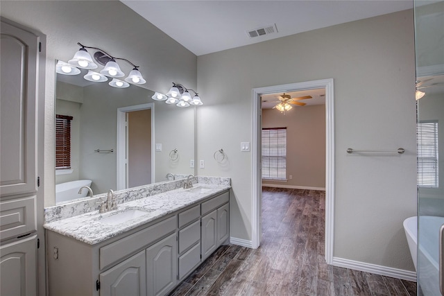 bathroom featuring hardwood / wood-style flooring, vanity, ceiling fan, and a bathtub