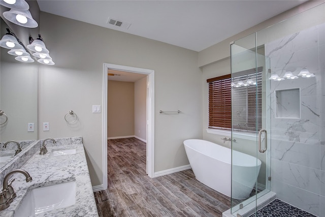 bathroom with independent shower and bath, vanity, and hardwood / wood-style floors