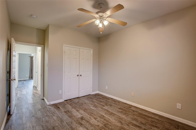 unfurnished bedroom featuring hardwood / wood-style floors, a closet, and ceiling fan