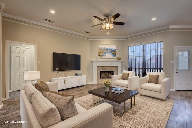 living room featuring crown molding, hardwood / wood-style flooring, a fireplace, and ceiling fan