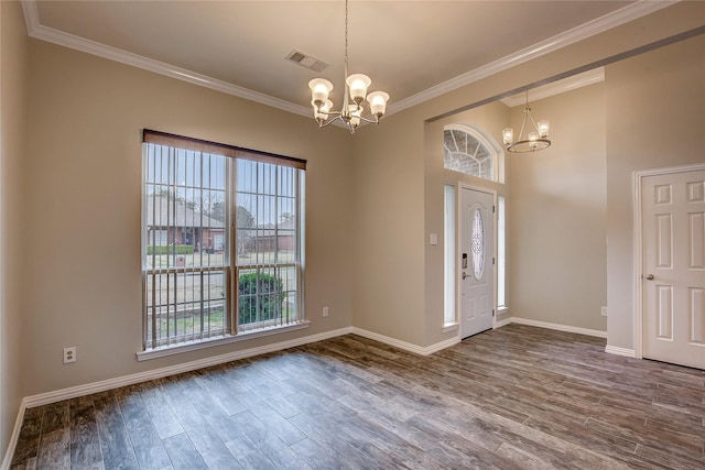 entryway with crown molding, hardwood / wood-style floors, and a notable chandelier