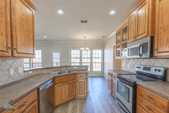 kitchen featuring stainless steel appliances, crown molding, sink, and light hardwood / wood-style flooring