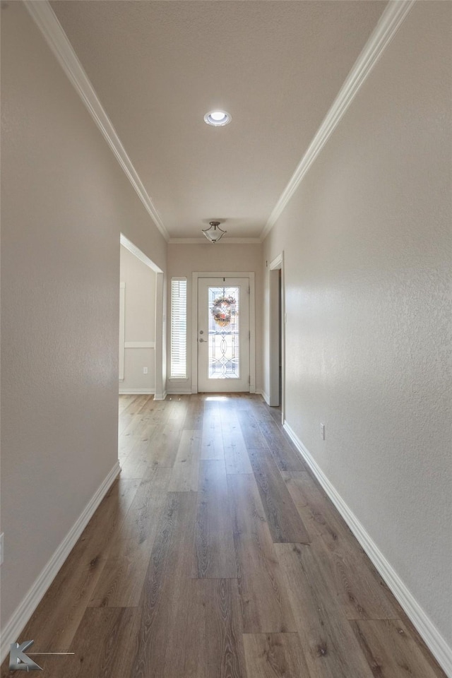 doorway to outside with crown molding and wood-type flooring