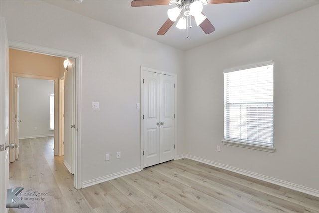 unfurnished bedroom with light hardwood / wood-style floors, a closet, and ceiling fan