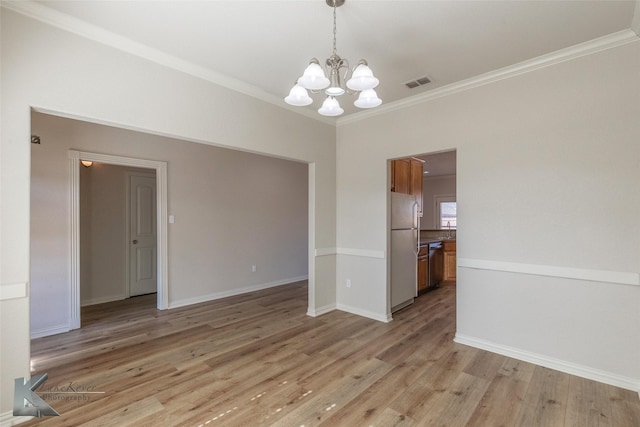 interior space featuring ornamental molding, a notable chandelier, and light hardwood / wood-style floors